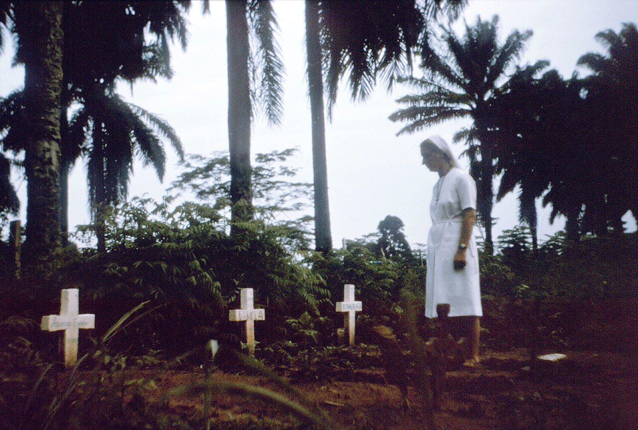 Zdravotná sestra na cintoríne s hrobmi obetí epidémie eboly v Zarie, r. 1976. © Wikimédia.org